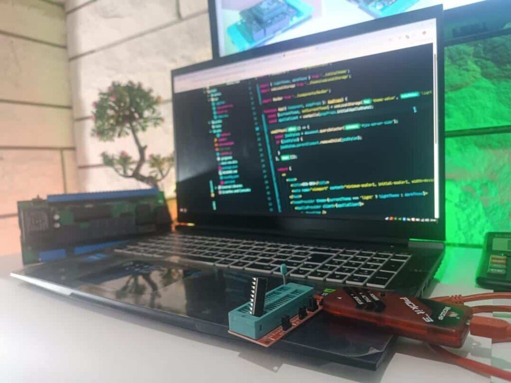 ön planda pickit3 üzerinde entegre, arka planda buğulu laptop ve online varlık modülü olan görsel