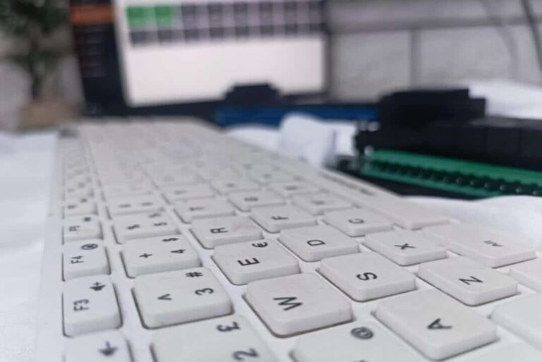 Öm planda bilgisayar klavyesi, arka planda buğulu varlık modülü ve laptop ekranı görseli