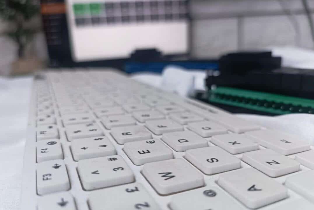 Öm planda bilgisayar klavyesi, arka planda buğulu varlık modülü ve laptop ekranı görseli