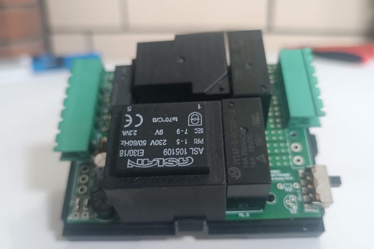 önde beyaz fon üzerinde TNS Otel enerji rölesi ve arka planda buğulu yankeski olan ürün görseli