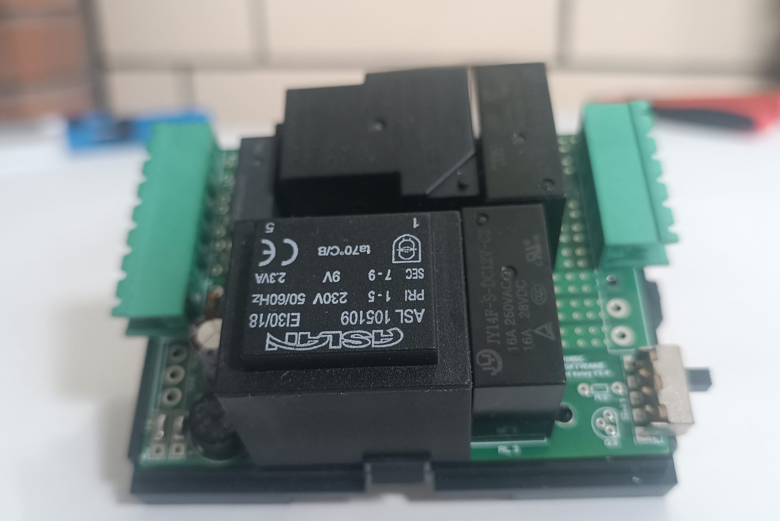 önde beyaz fon üzerinde TNS Otel enerji rölesi ve arka planda buğulu yankeski olan ürün görseli